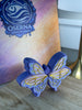 Angled view of the large purple butterfly clicker