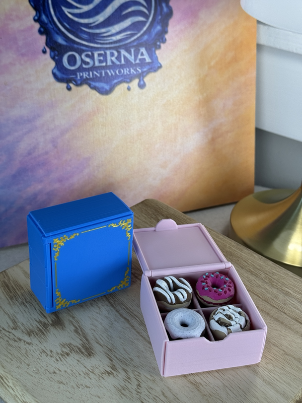 Open pink donut clicker box beside a closed blue decorative box