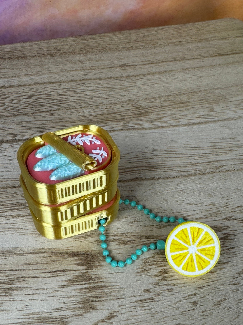 Open sardine clicker keychain shown from an angled top view